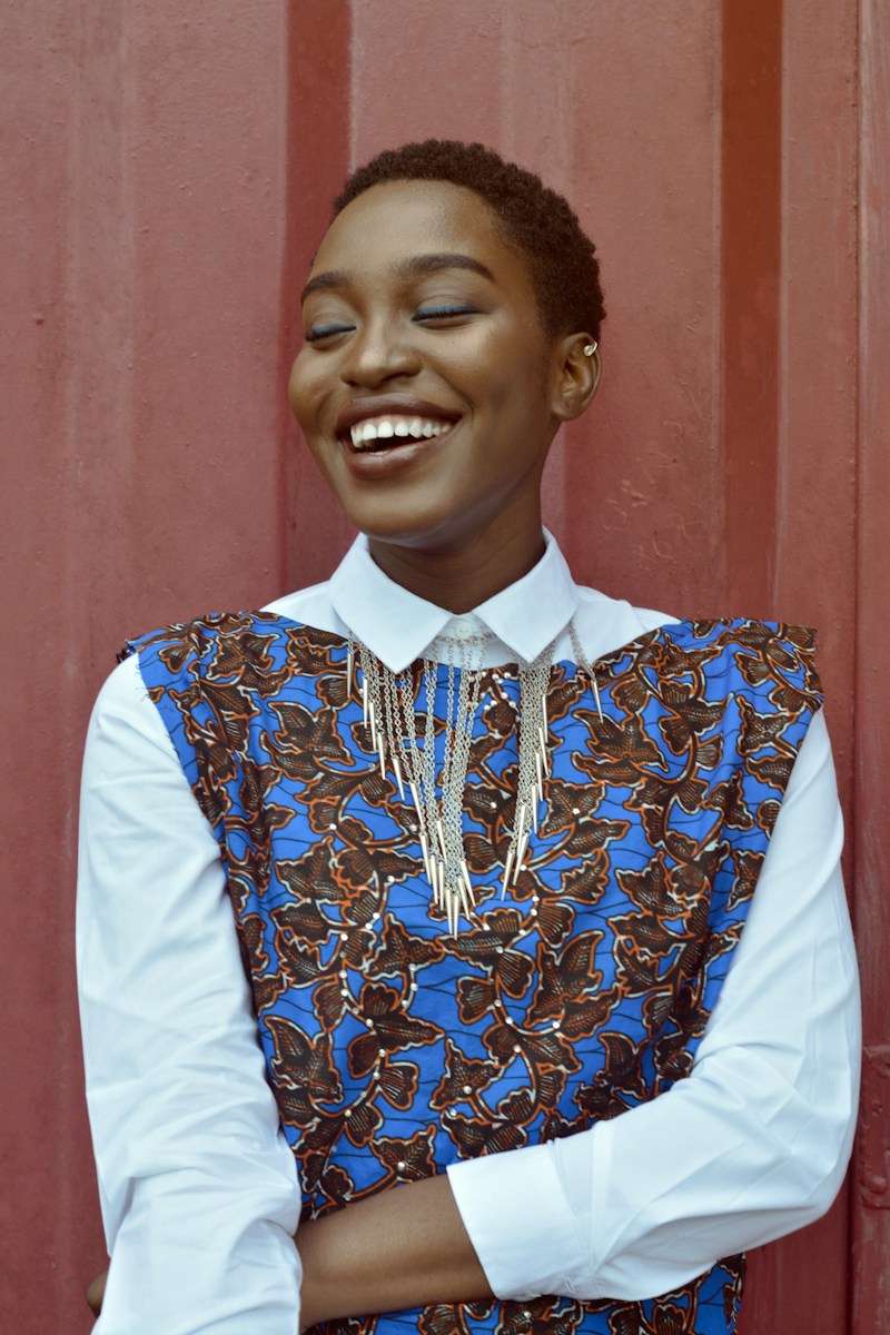 woman smiling beside red wall