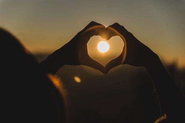 Hands making the shape of a heart with the sound in the middle for valentine